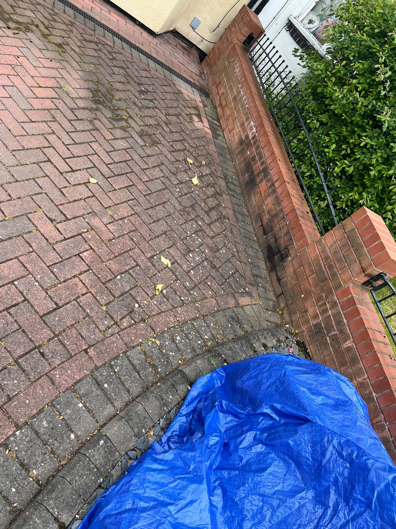 Close-up of the same dirty brick wall corner before pressure washing