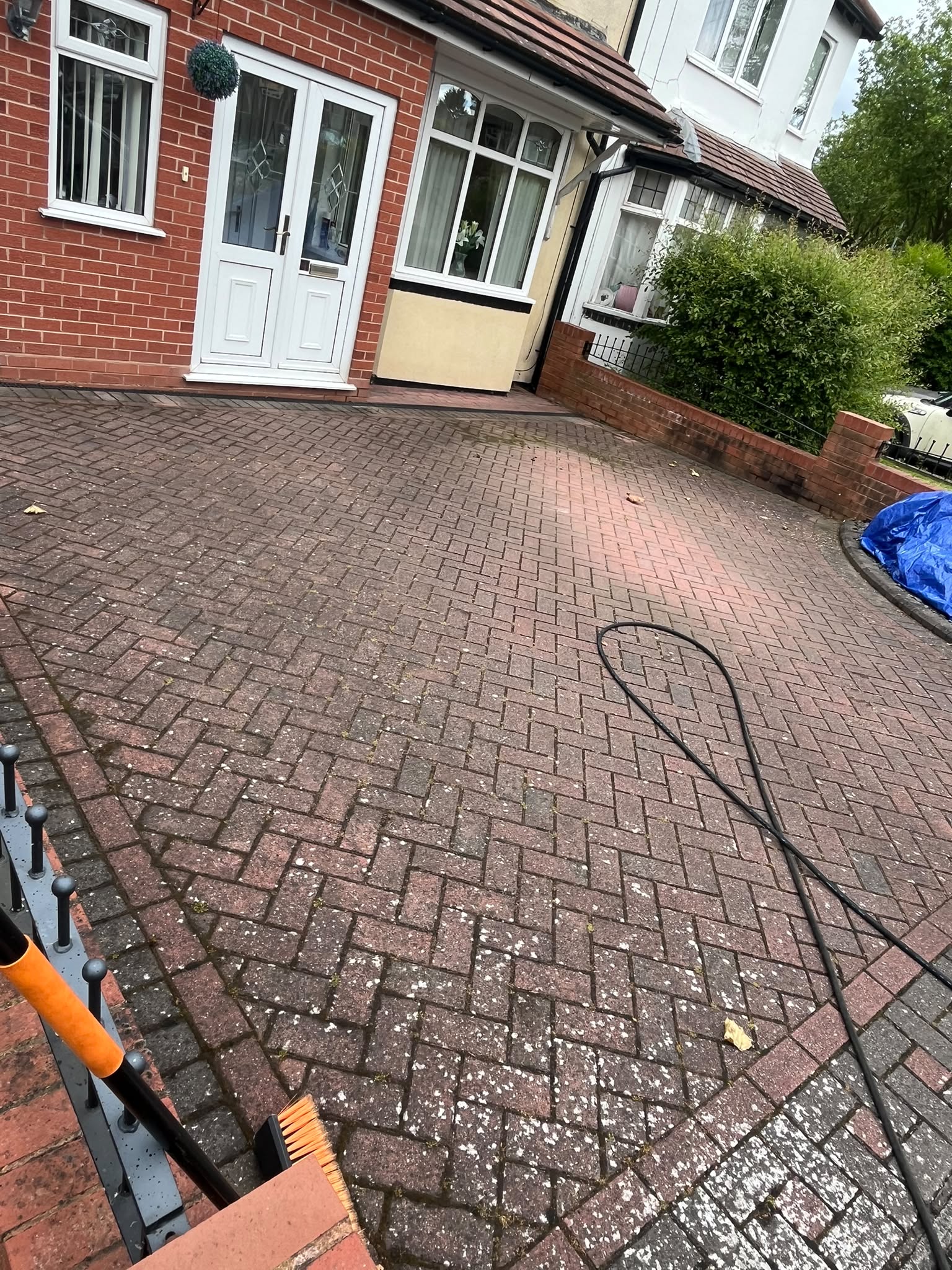 Heavily moss- and algae-stained block-paving driveway before pressure washing