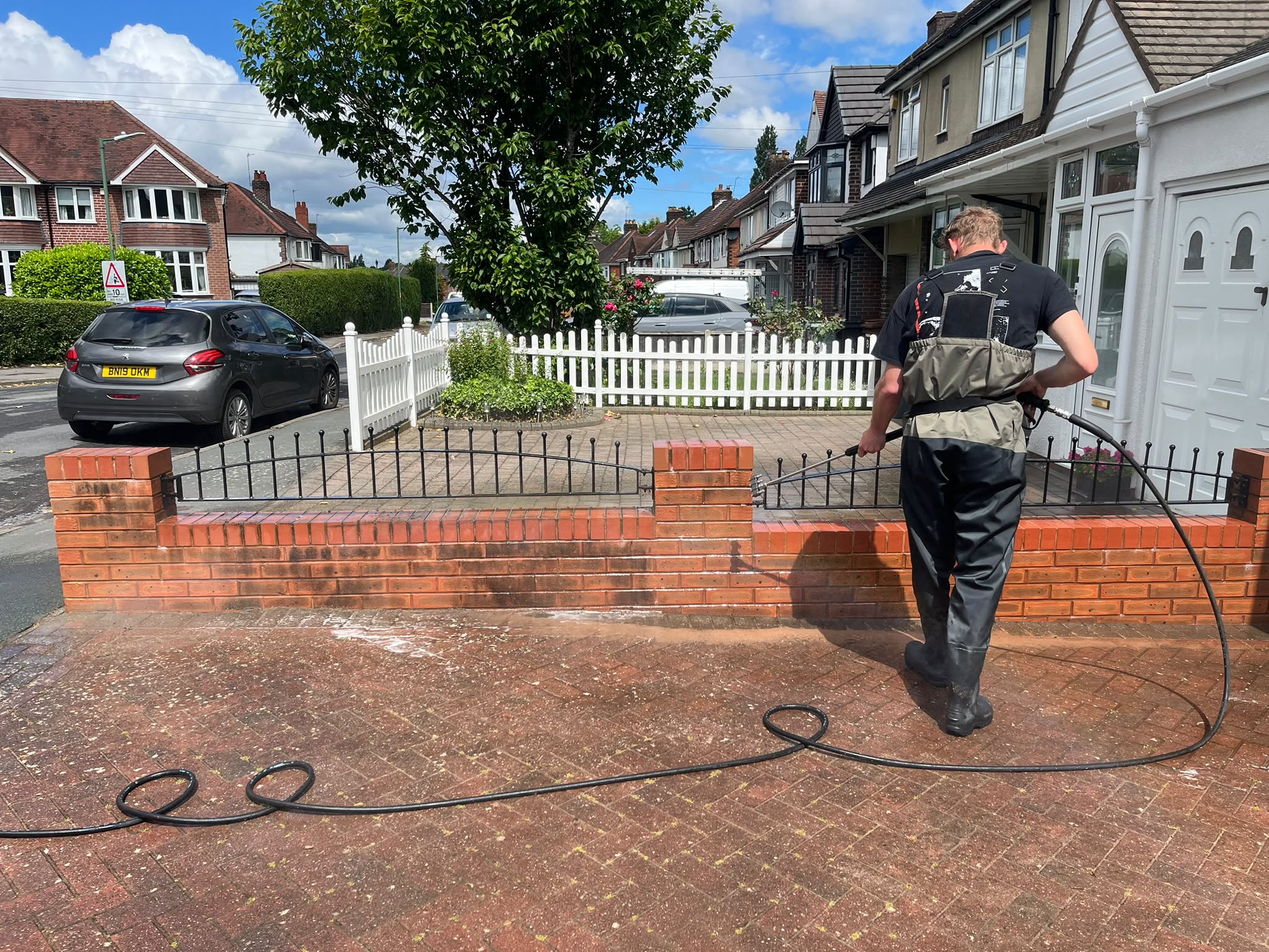 Morgan & Walker technician pressure washing a garden wall