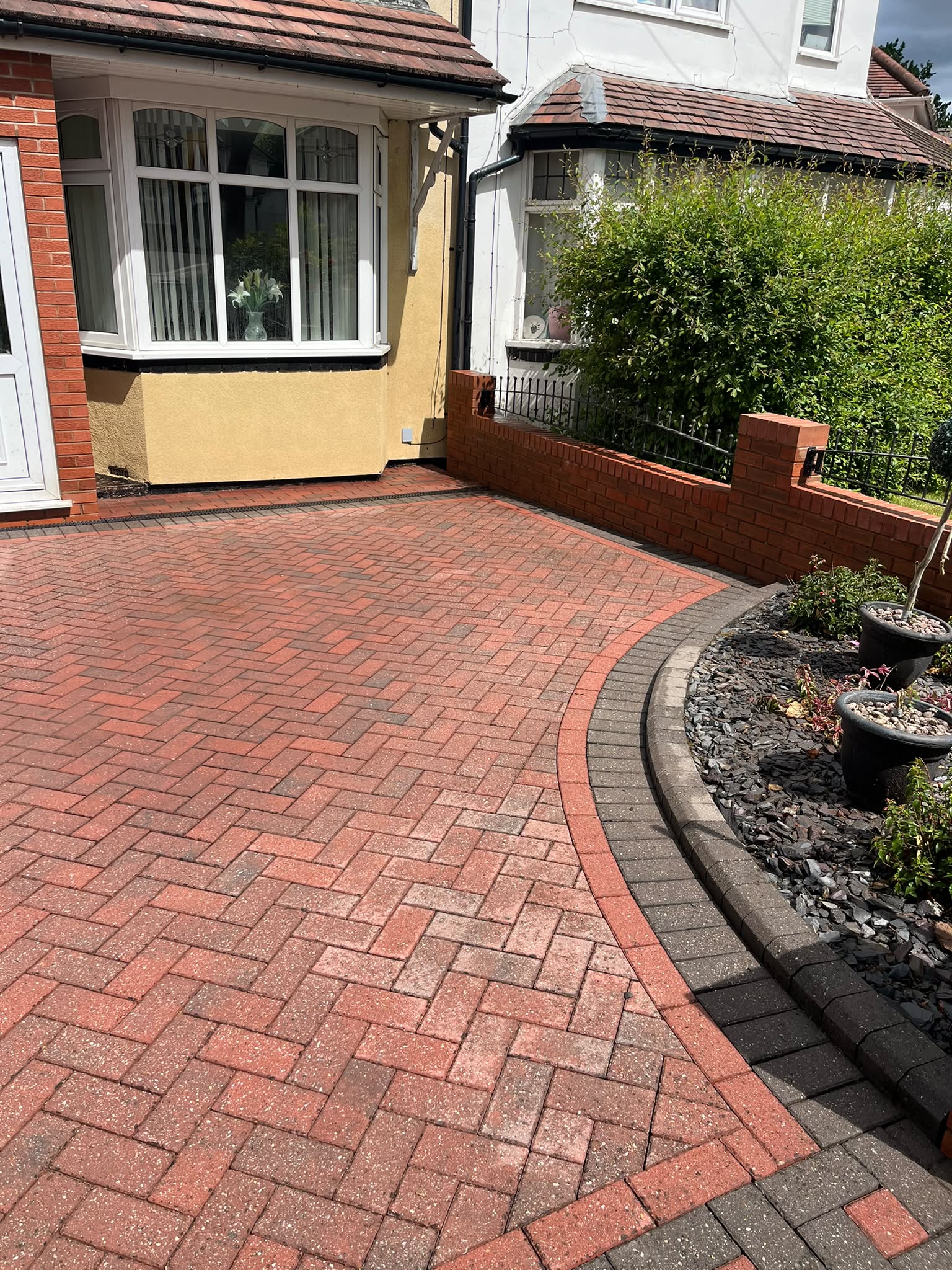 Clean block-paving driveway after pressure washing, house number visible on the garage
