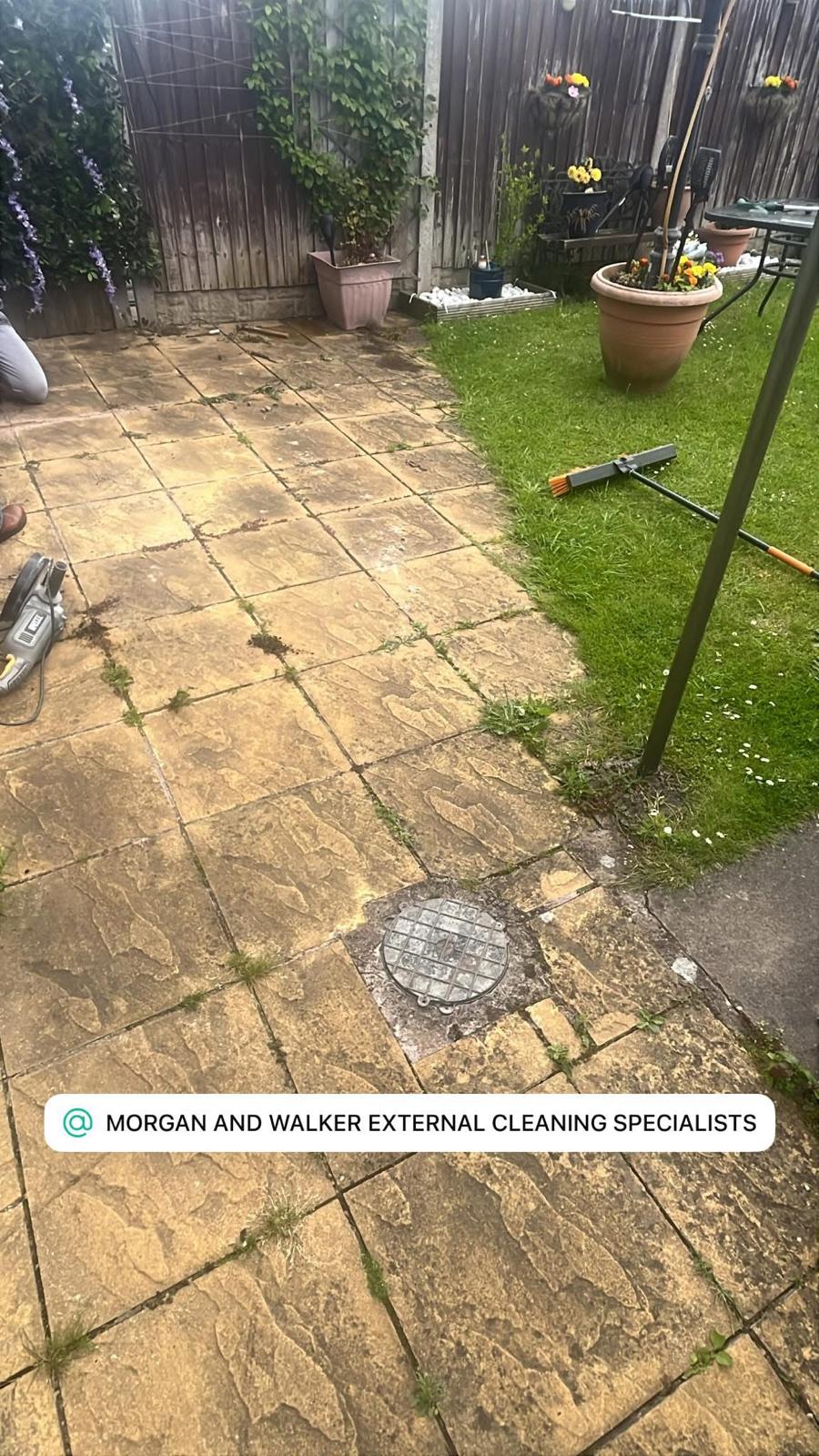 Dirty square-slab rear patio before pressure washing