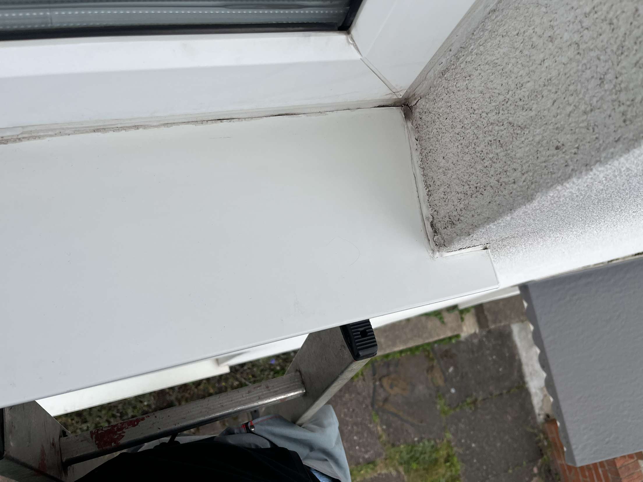 Detail of a grimy window sill and frame corner before cleaning