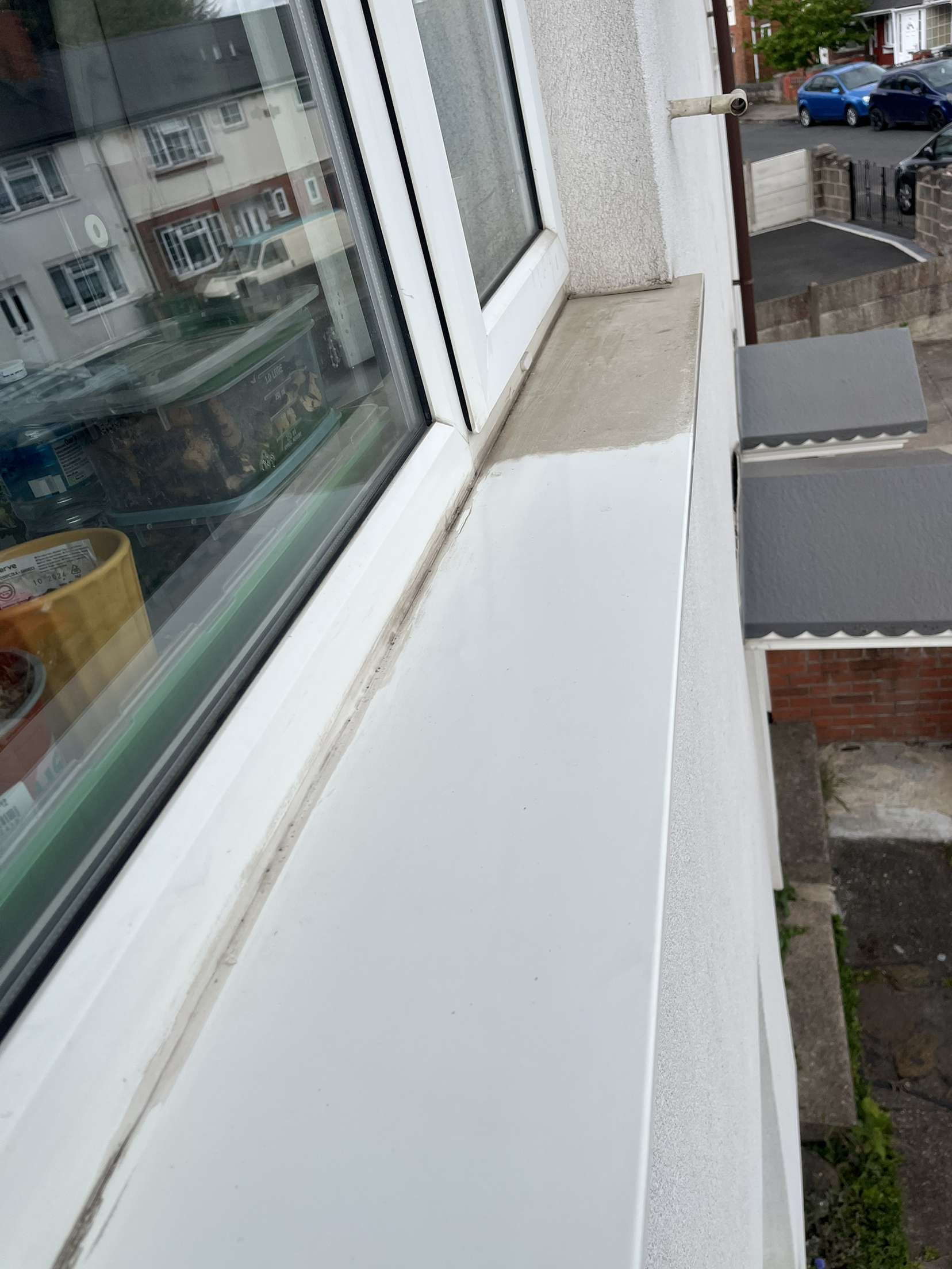 Detail of a grimy window sill and frame corner before cleaning